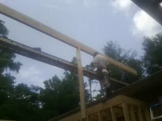Carpenter setting a ridge beam over a new addition frame — Ice Dam Removal by Roofing Brothers in Caseyville