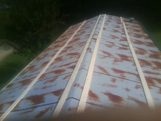 Rusted metal roof panels with new wood purlins before replacement — Storm Damage Roof Repair in Caseyville by Roofing Brothers