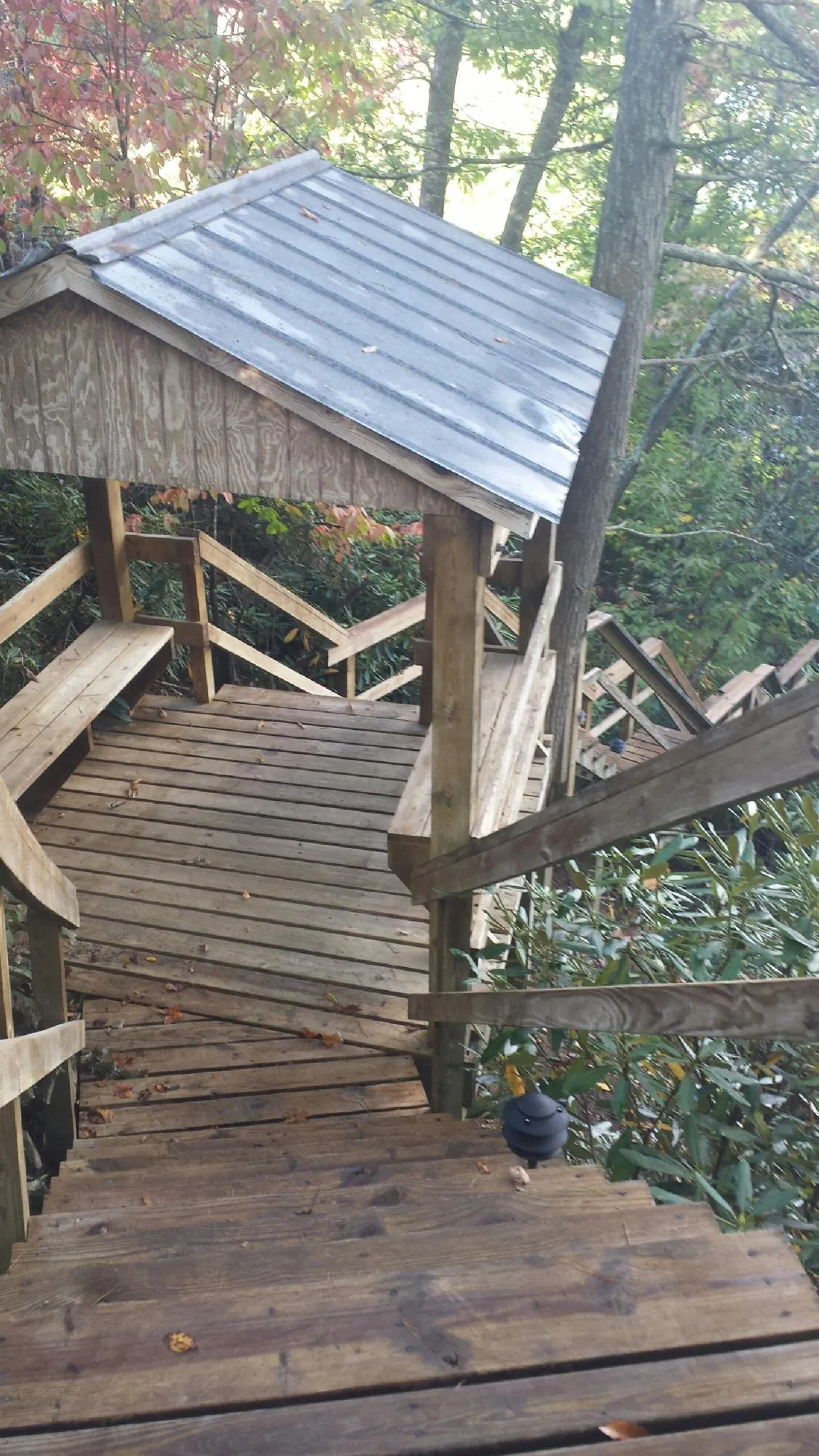 Metal roofed shelter over wooden steps on a wooded walkway — Skylight Repair & Installation work by our crew in Caseyville